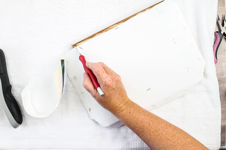 trimming away excess material with a craft knife