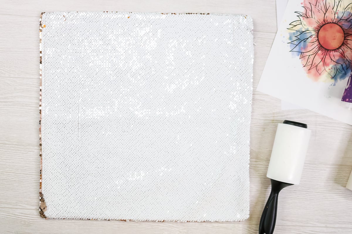 using a lint roller on a sequin pillow cover