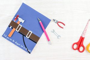 using a knife to put holes in a father's day card