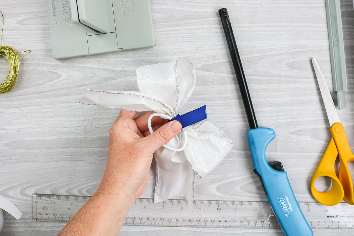 wrapping ribbon around the middle of a bow