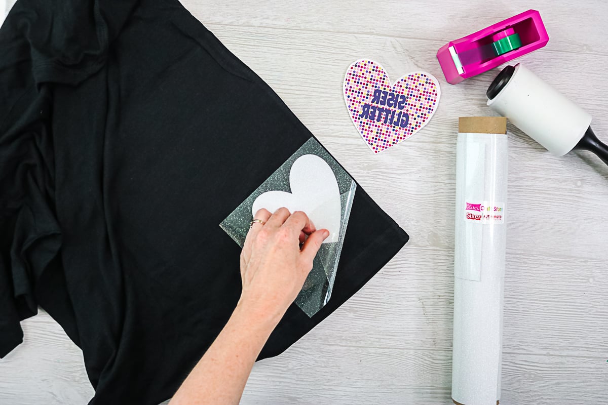 applying sister glitter htv to a black shirt