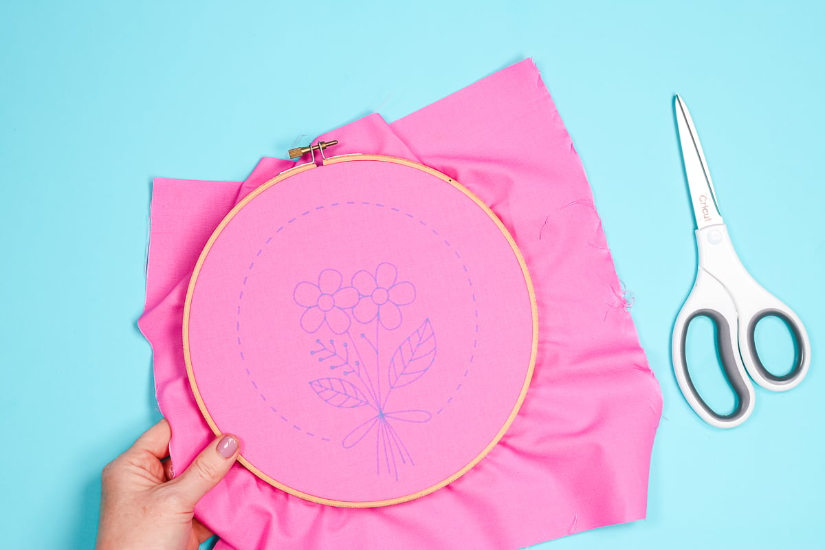 pink fabric with embroidery pattern in a hoop
