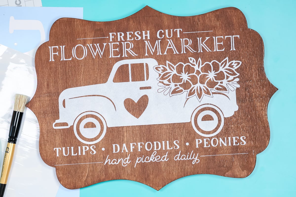 Finished Stenciled sign with truck and flowers painted on it.