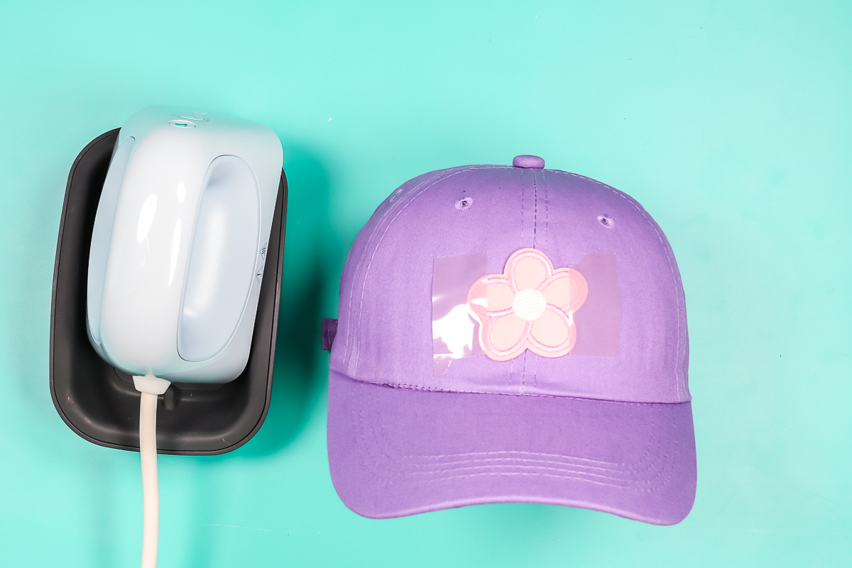 Embroidered flower iron-on patch taped onto hat with heat tape.