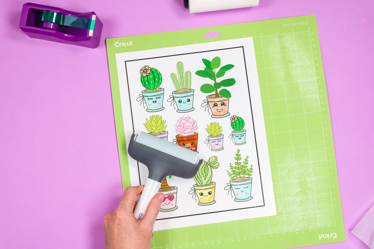 adding cactus stickers to a green cricut mat