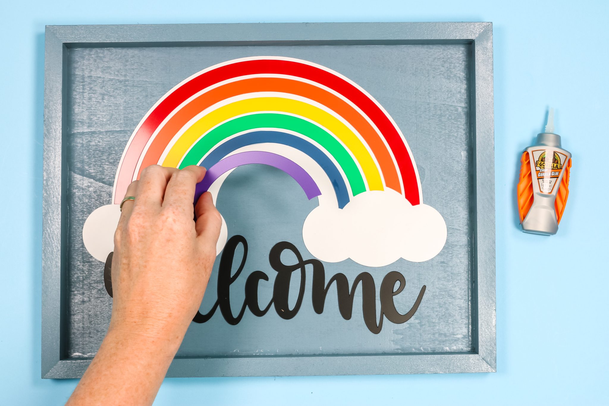Assembling rainbow welcome sign.