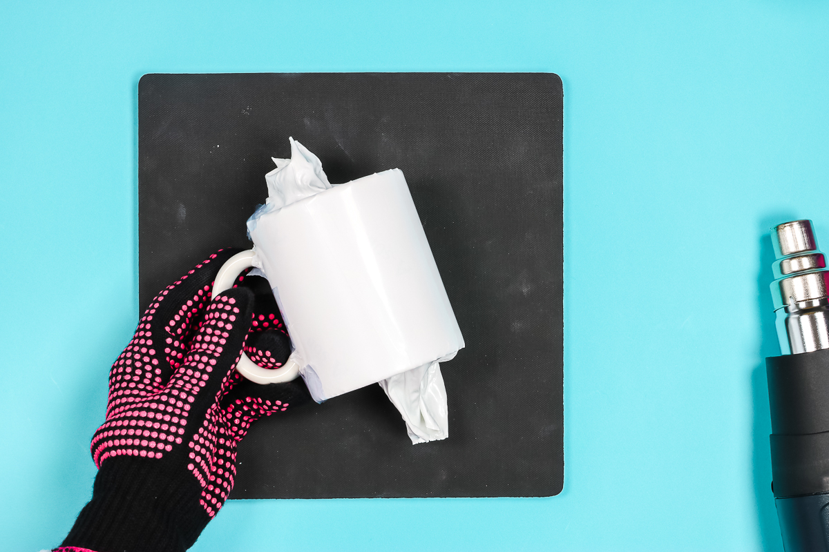 Use a heat gun to shrink the wrap around the mug.