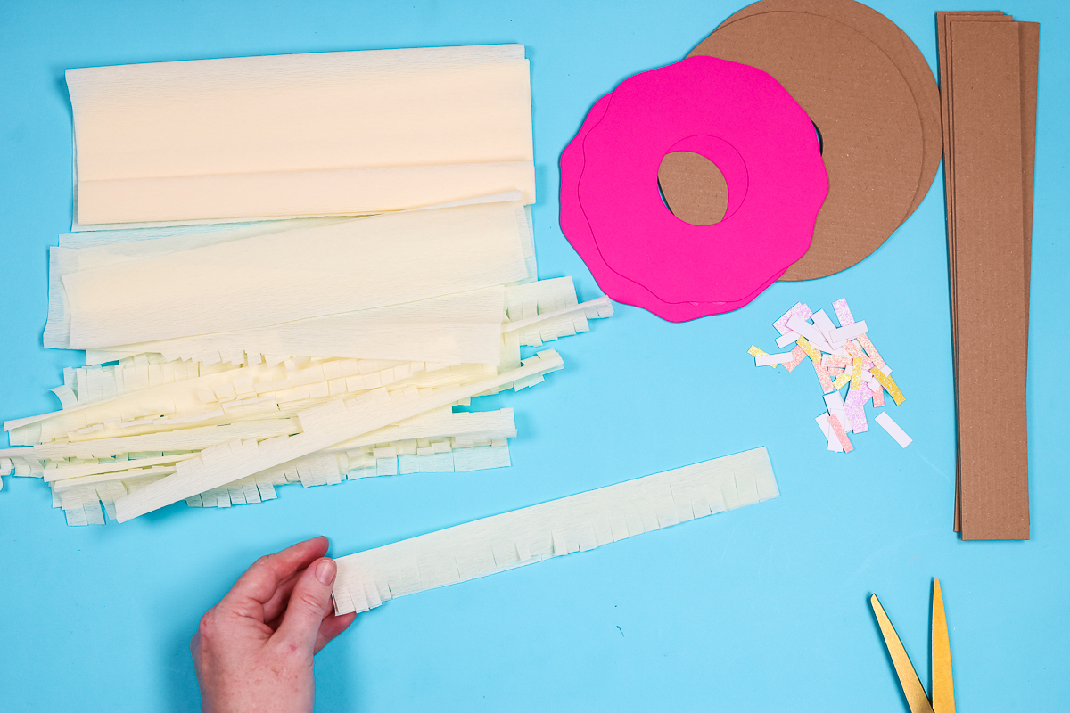 Cut crepe paper to add to piñata.