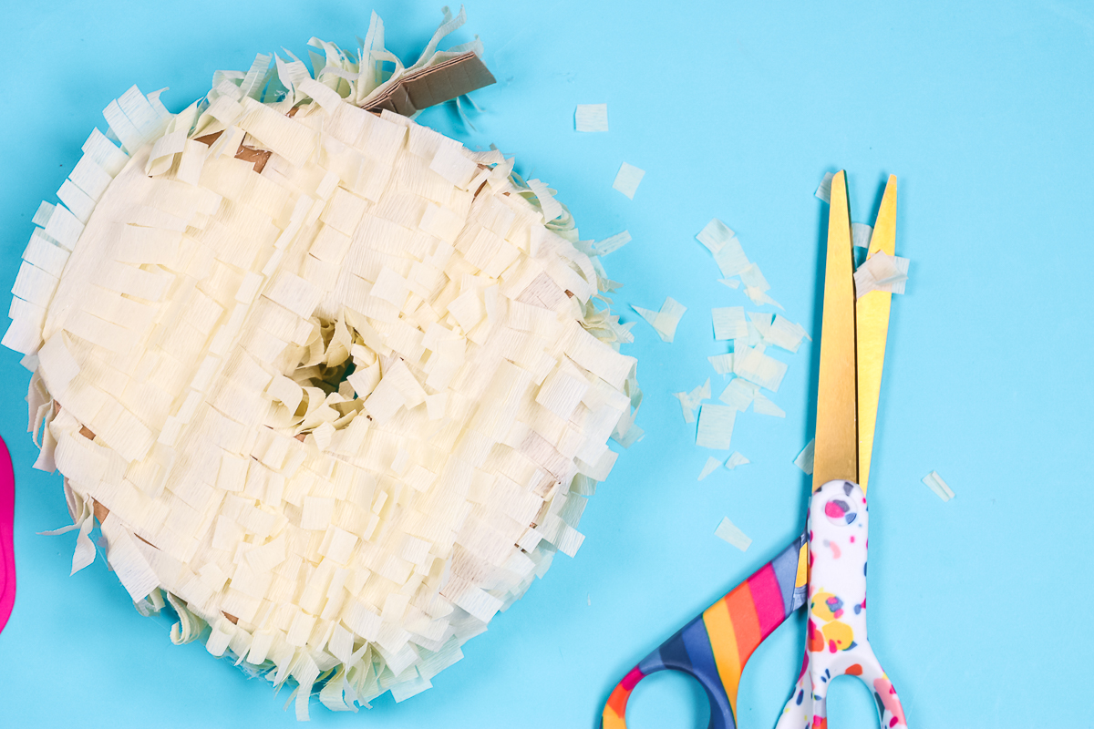 Use scissors to trim excess crepe paper from middle of donut.