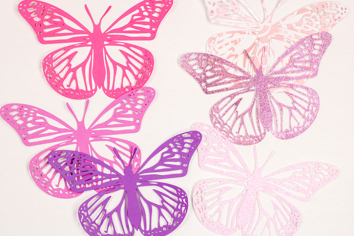 Multiple intricate cut cardstock butterflies.