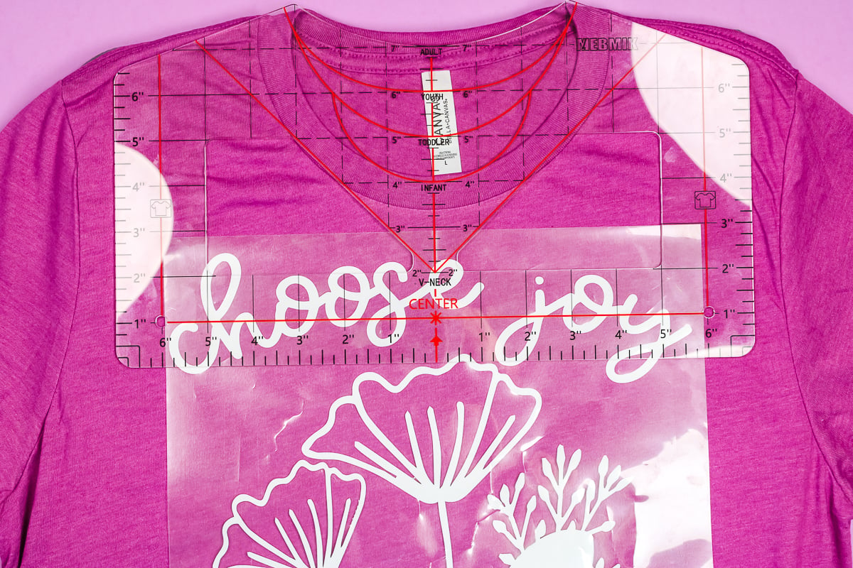 Lining HTV t-shirt design under placement guide ruler.