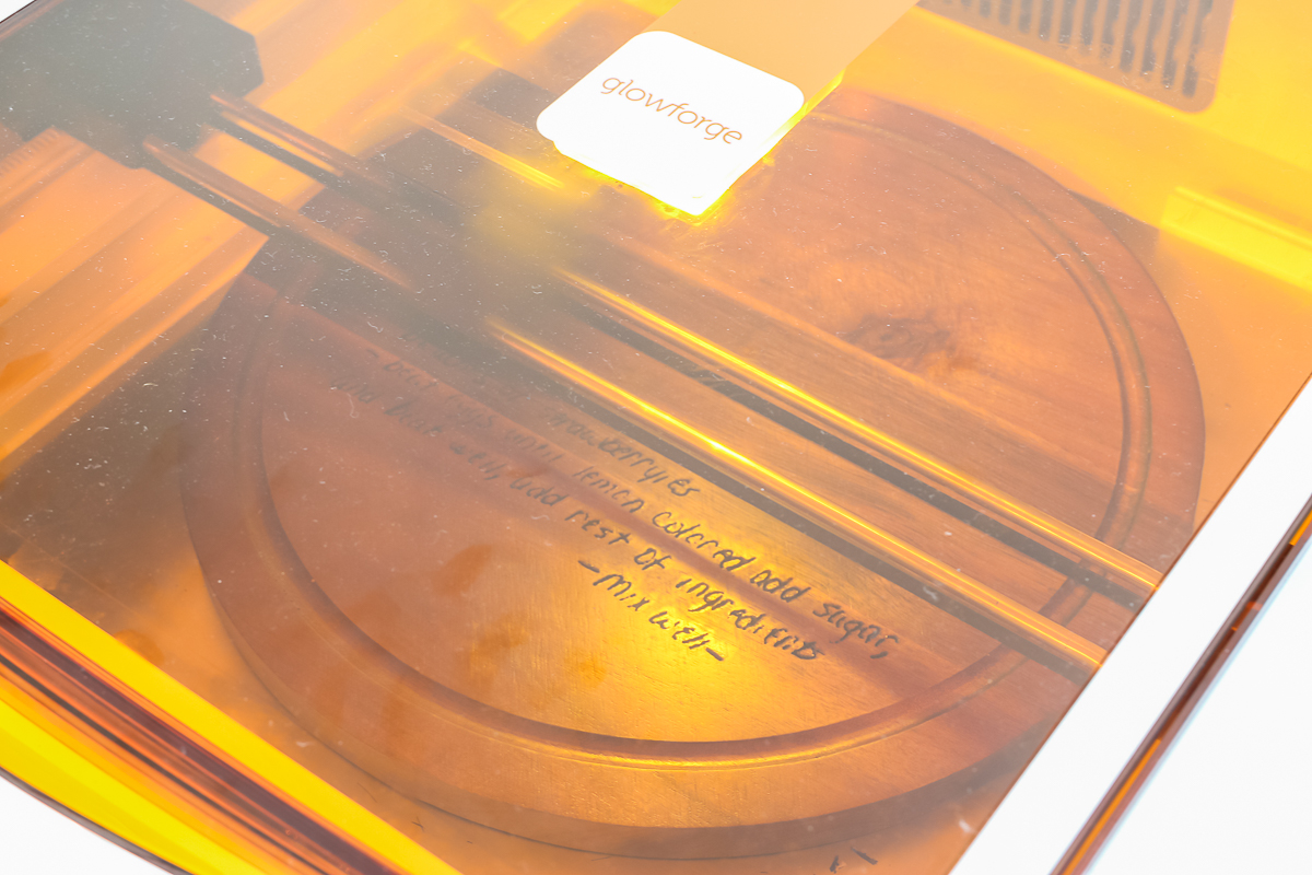 Round wood board being engraved in Glowforge Aura.