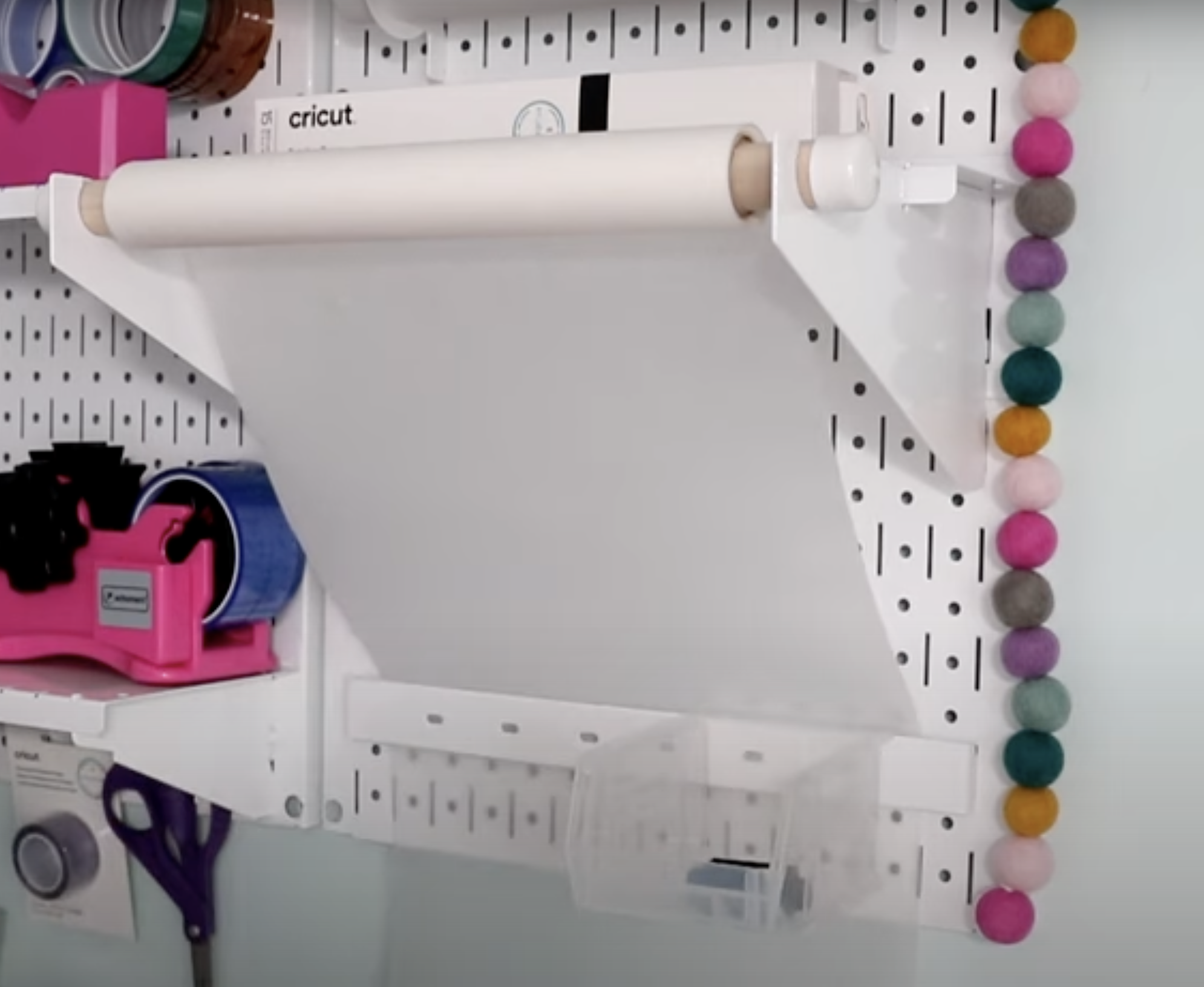 Sublimation protective paper roll fed behind rail on Wall Control Pegboard.
