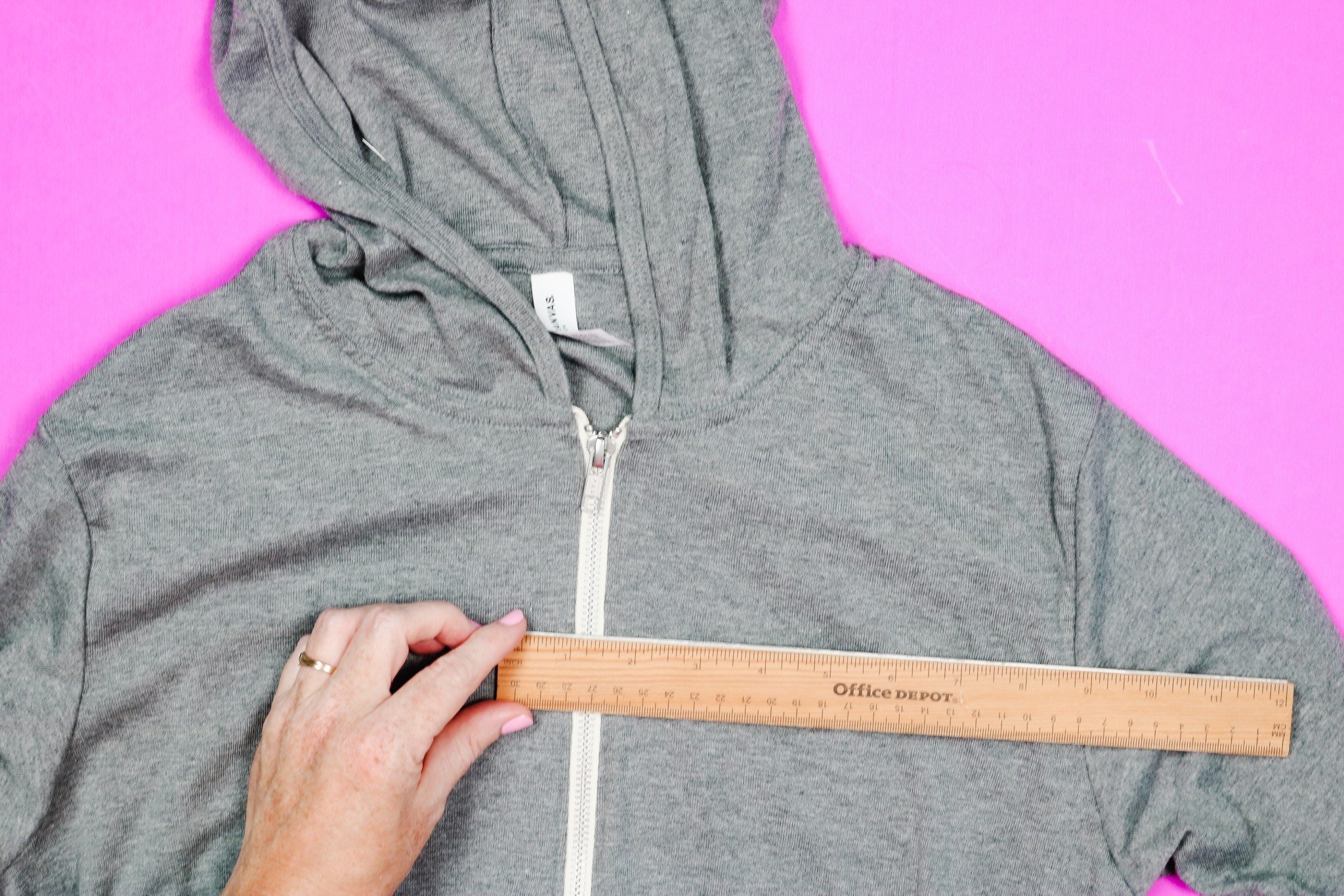Use a ruler to measure width of hoodie zipper.