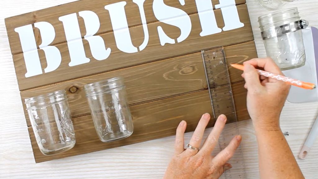 Measure to place jars even on wood sign.