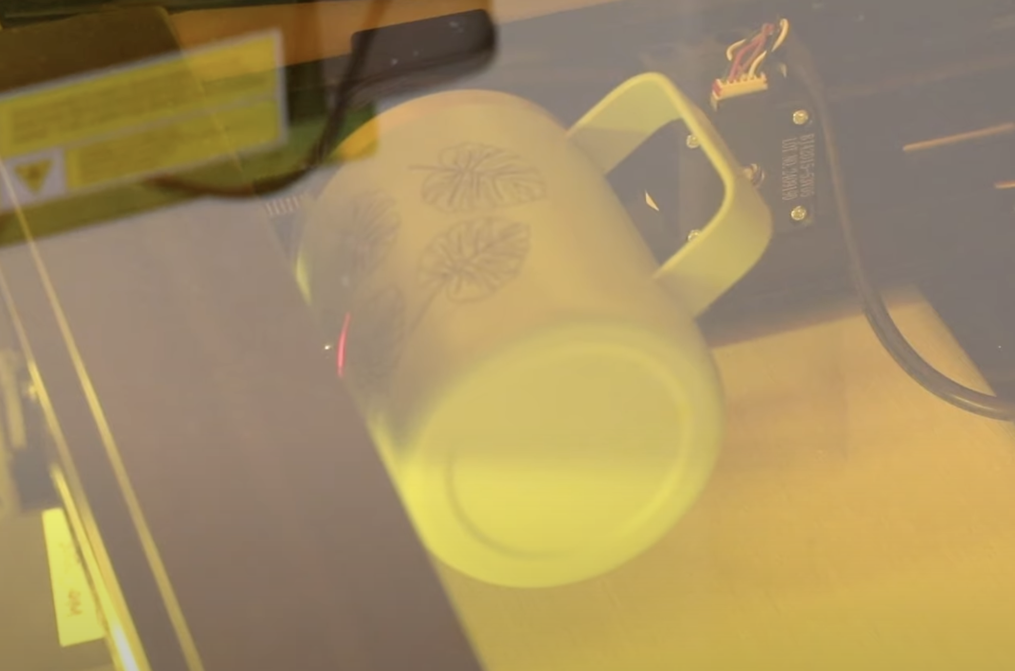 Tumbler being engraved inside WeCreat laser.
