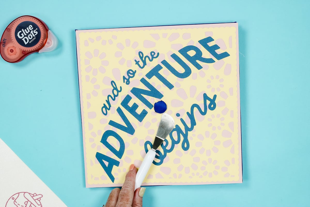 Use a tool to work the cardstock under the button.