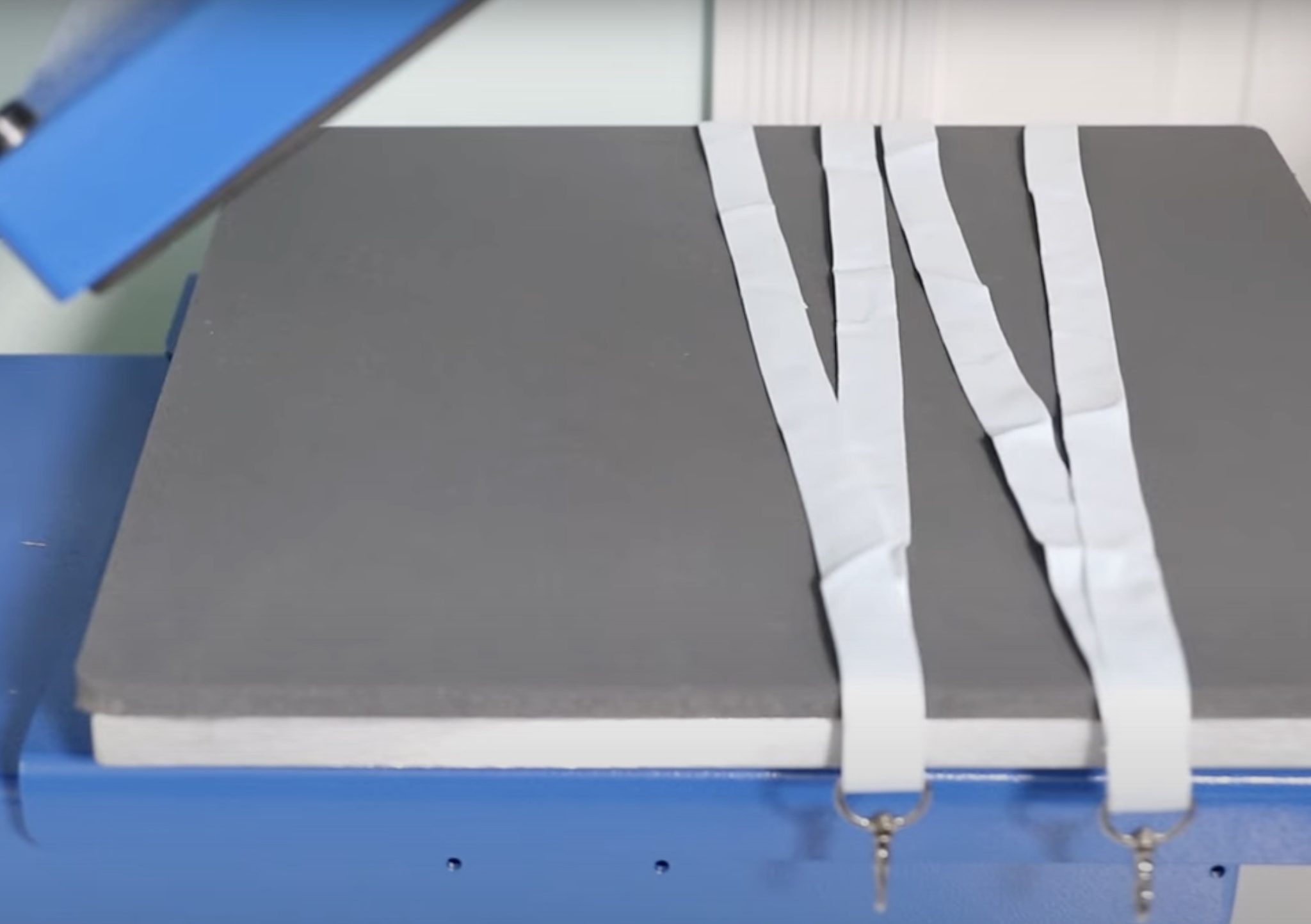 Locate lanyards in heat press with ends hanging out.