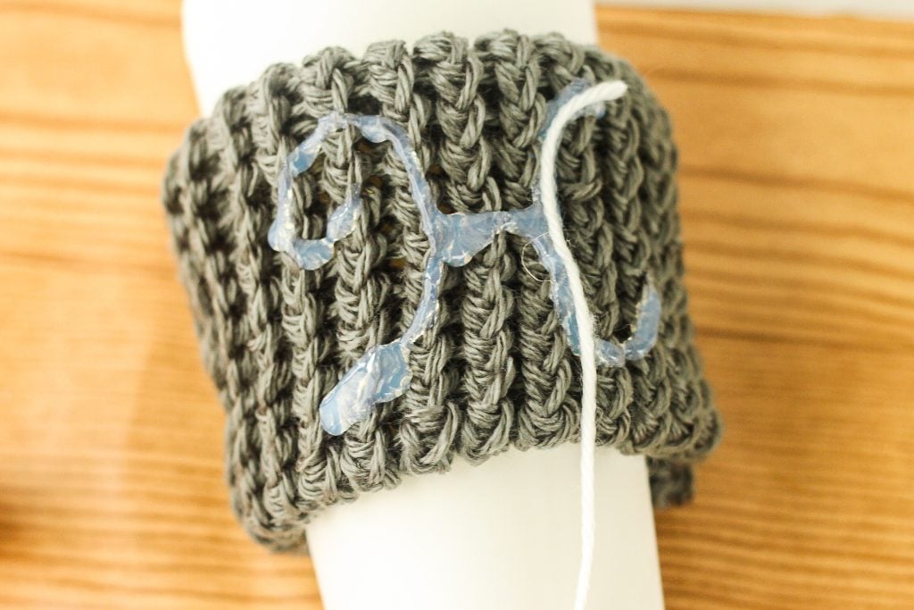 Gluing yarn monogram on knit sleeve