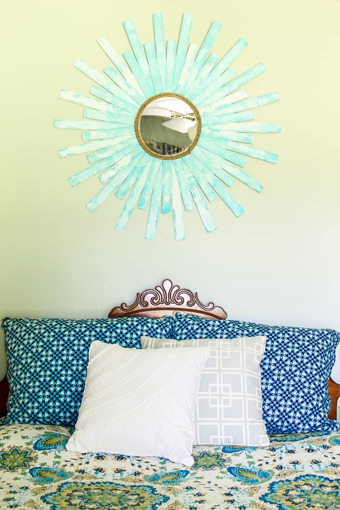 starburt mirror hanging over a bed
