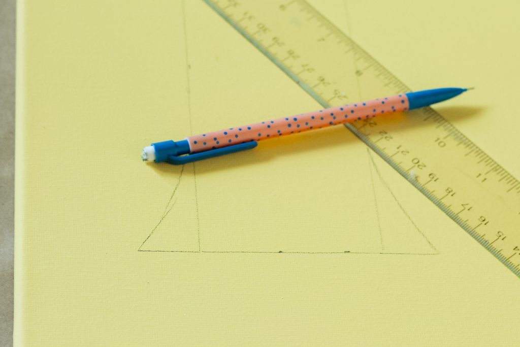 pencile and ruler to draw monogram on painted canvas