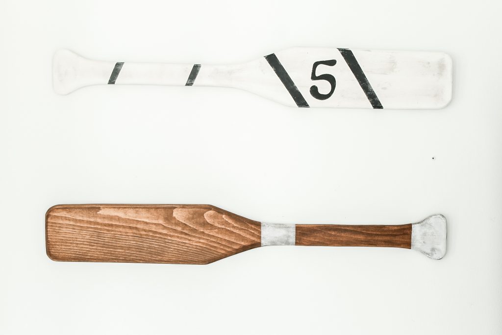 decorated oars hanging on bathroom wall