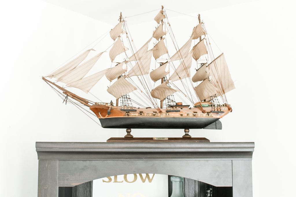 ship with sails on top of bathroom shelving unit