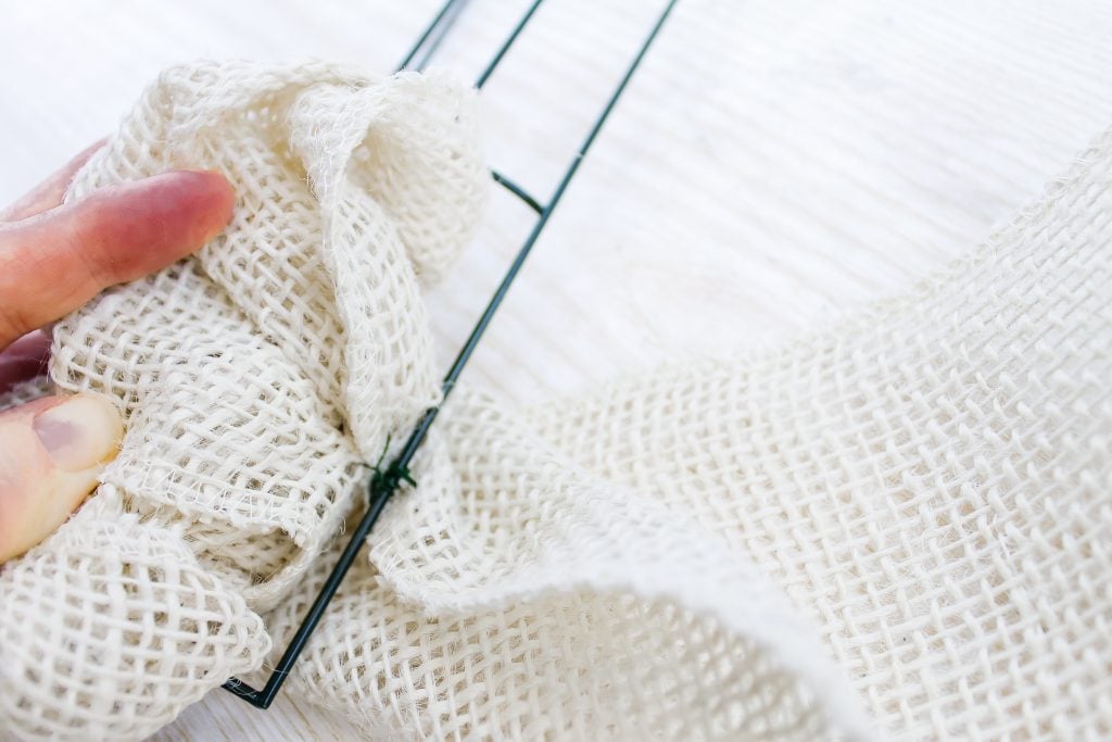 adding white burlap ribbon to wire fream with floral wire