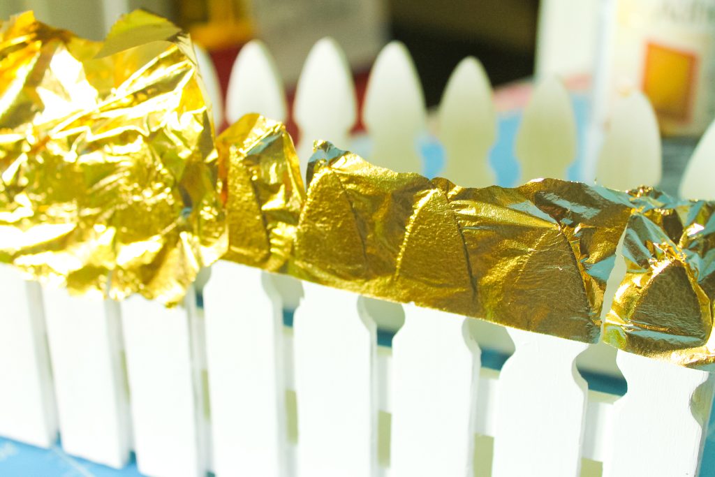 Placing gold leaf on top of adhesive