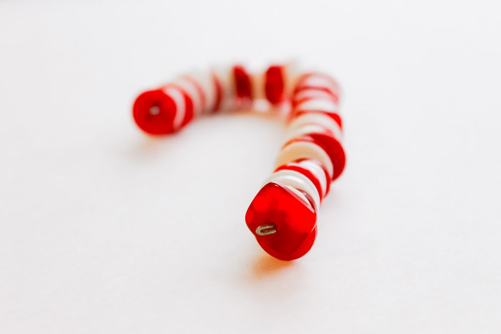 Button Candy Cane Christmas Ornaments -- handmade ornament tutorial that will have your tree full of button candy canes in no time. buttons threaded onto a piece of wire