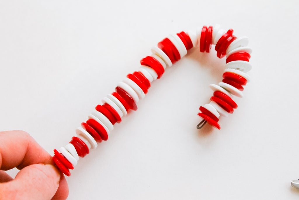 Button Candy Cane Christmas Ornaments -- handmade ornament tutorial that will have your tree full of button candy canes in no time. holding the buttons onto the wire