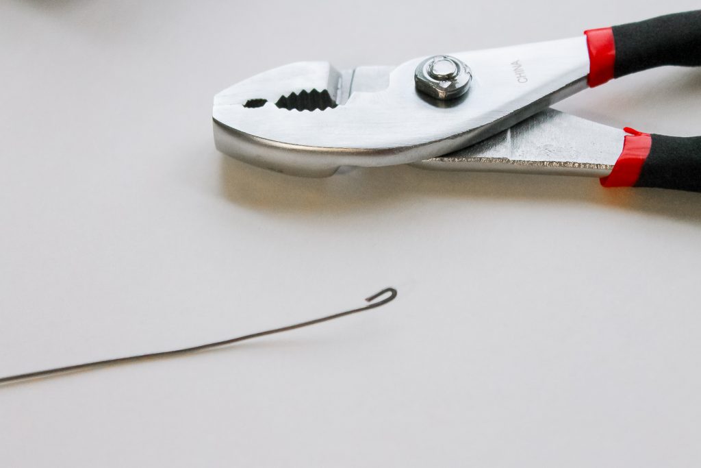 Button Candy Cane Christmas Ornaments -- handmade ornament tutorial that will have your tree full of button candy canes in no time. using pliers to bend a stop into the wire