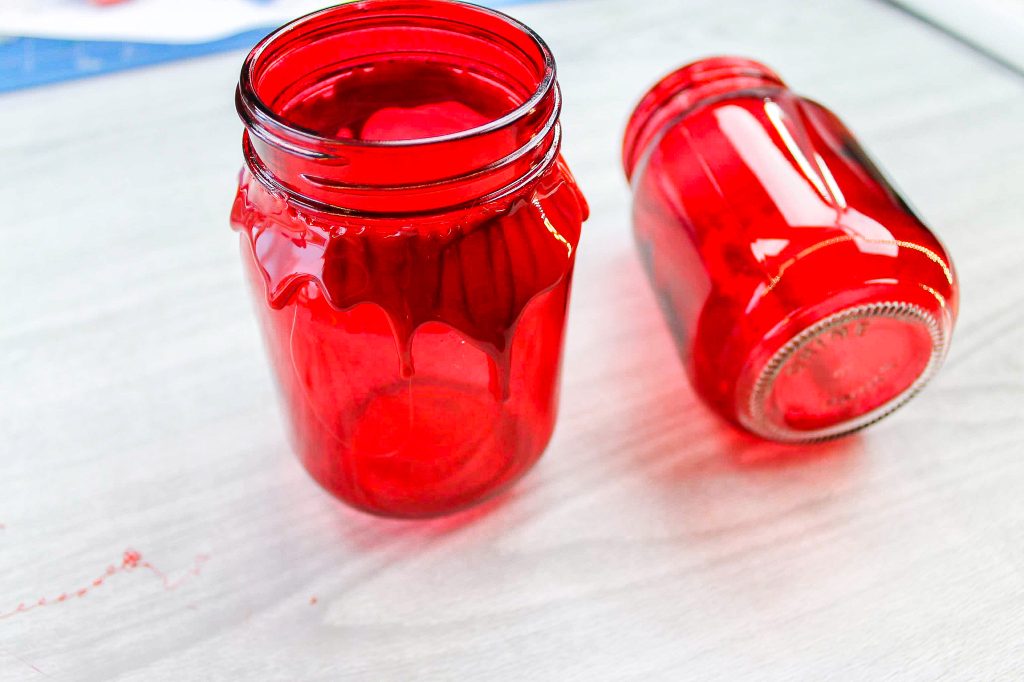 adding melted red glue sticks to red mason jars