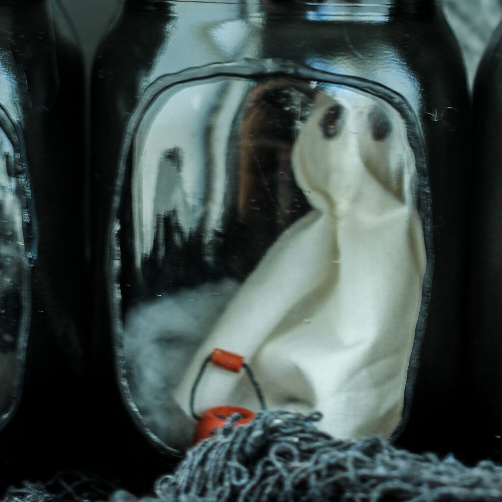 ghost peeking out of a painted mason jar