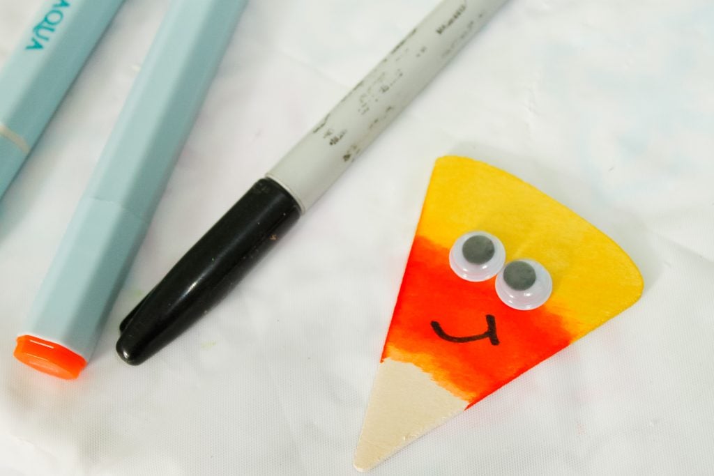 Google eyes and mouth added to colored wood pie piece