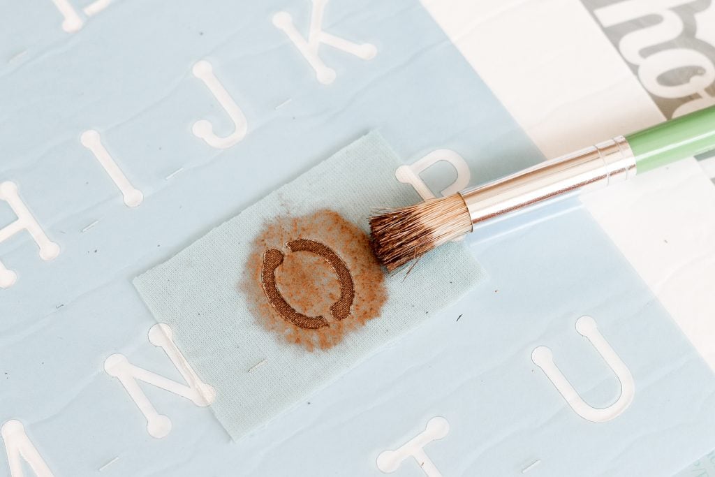 Stencil with stiff brush and gold paint