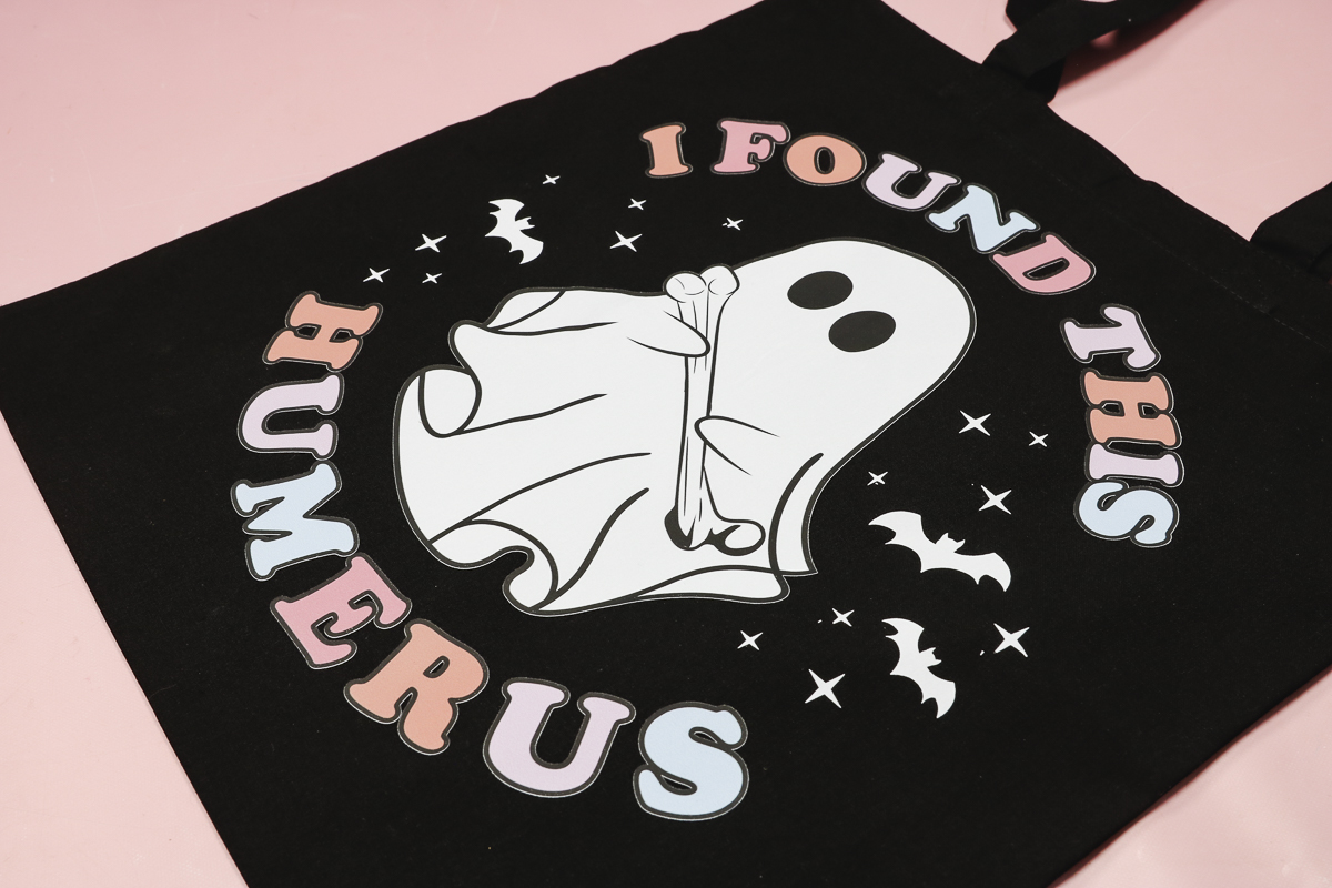 Glow in the dark DTF trick or treat bag in the light.