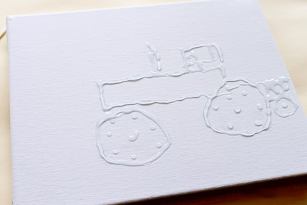 Tractor drawn with glue on a stretched canvas