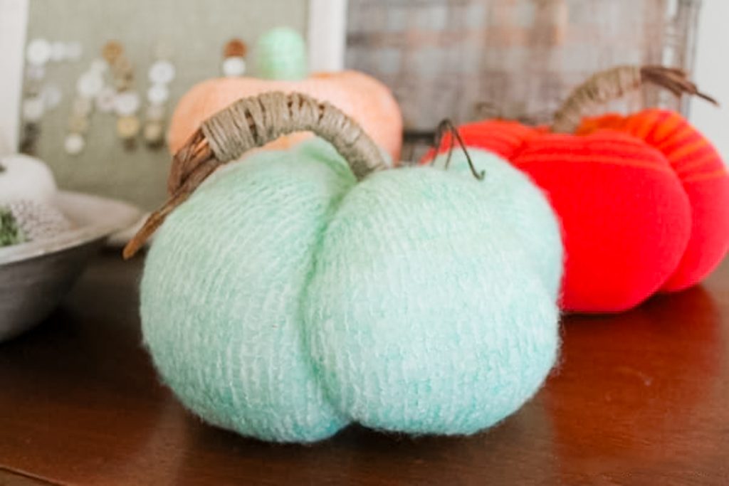 one green pumpkin with orange in the background