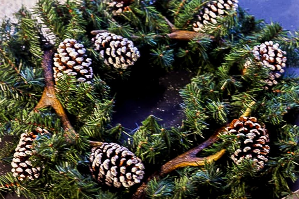 adding pincones to a wreath