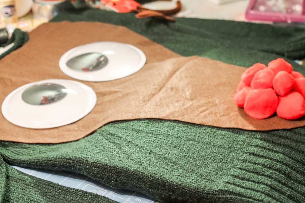 Red pom poms and large google eyes on brown felt