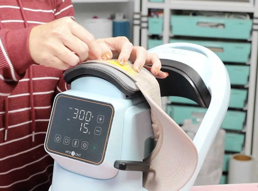 adding htv to the side of hat while it is in the hat press