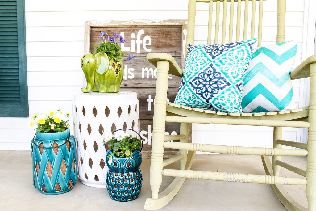 planters, pillows and rocking chair on a porch
