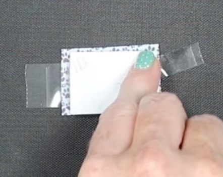 Sandwich the dog tag between prints.