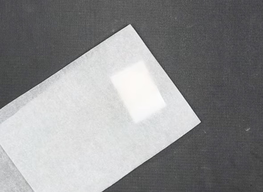 Add protective paper to the top and bottom of the dog tag.