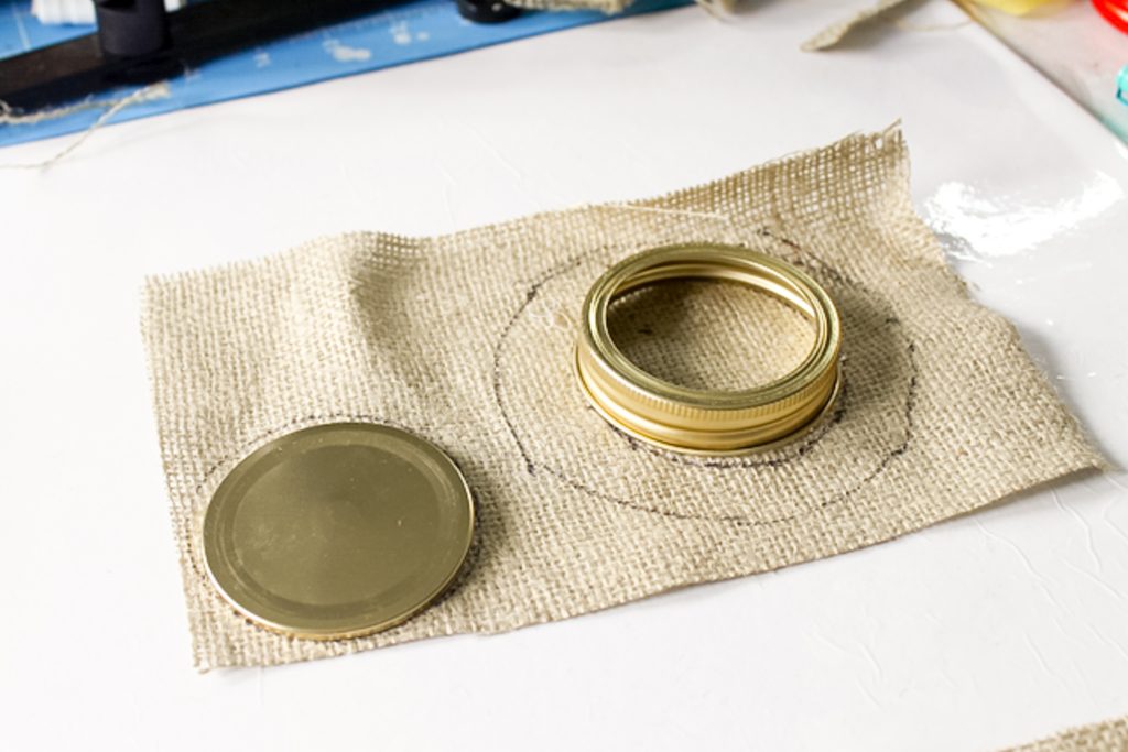 tracing a jar lid onto a piece of burlap