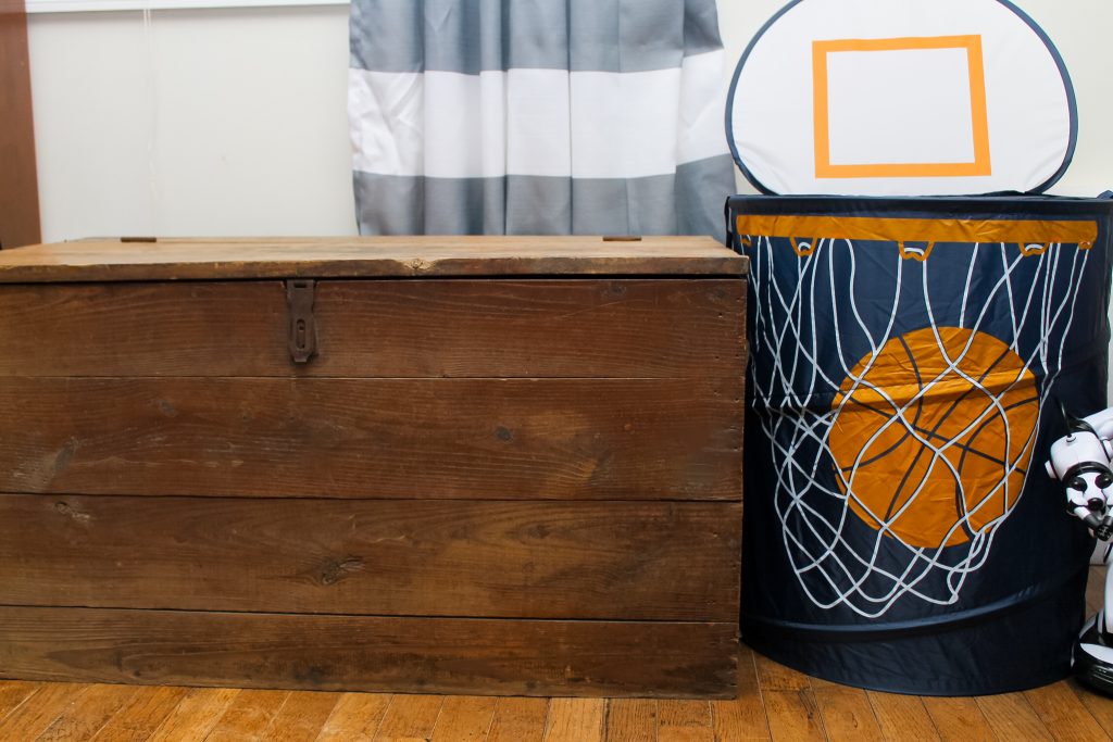 Wood trunk and basketball hamper in a bedroom