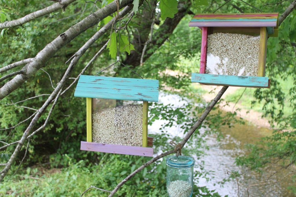 brightly colored painted bird feeders