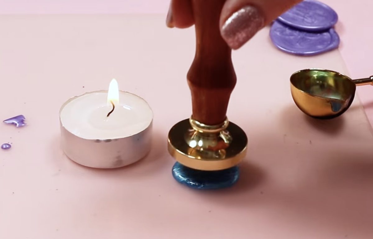 Place the custom wax seal stamp in the center of the melted wax.