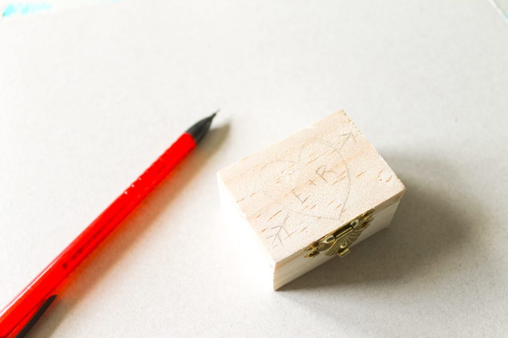 pencil-sketched design on a wooden box